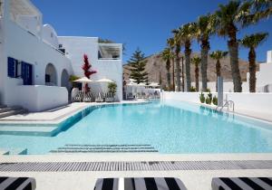 佩里萨Kouros Village Hotel - Adults Only的一座棕榈树游泳池和一座白色的建筑