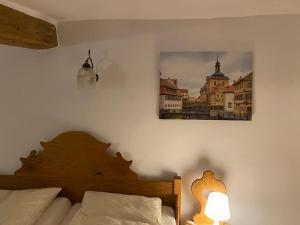 班贝格祖姆艾特尼豪斯拉公寓的卧室配有一张床,墙上挂着一幅画