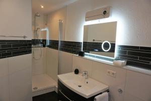 科布伦茨扬凡韦特酒店的一间带水槽、淋浴和镜子的浴室