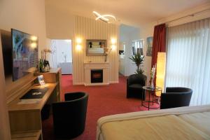 科布伦茨扬凡韦特酒店的酒店客房配有一张床和一个壁炉。