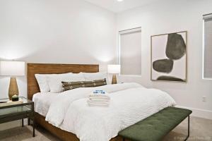 圣乔治Villa #24 at Bloomington Country Club的白色卧室配有一张带绿色搁脚凳的大床