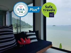 波湾8IK88 Resort - SHA Extra Plus的蓝色的沙发,带有枕头,还有一个标有安全旅行的标志