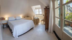 热那亚Attico Palazzo Giustiniani的卧室配有白色的床和窗户。