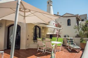 阿塔玛丽亚Luxuriöse und großräumige Villa mit Community Pool, Sicht auf das Mittelmeer sowie dem Mar Menor, La Manga Club的庭院配有桌椅和遮阳伞。