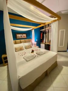 阿拉卡茹Pousada Encantare的一间卧室配有一张带天蓬的白色床