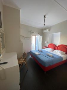 科里夏AEGEAN VIEW SEASIDE ROOMS AND STUDIOS KEA的一间卧室配有一张带红色椅子的床和一张书桌