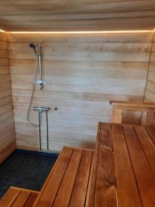 艾赫泰里Villa Hiili的一个带木桌和淋浴的桑拿浴室