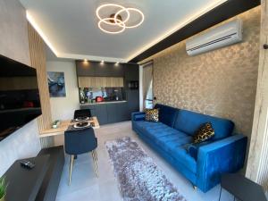 凯斯特海伊Relax Sauna Apartman privát finn szaunával的客厅配有蓝色的沙发和桌子