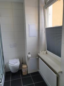 赛巴特班森Hotel Domke Haus an der See的白色的浴室设有卫生间和窗户。