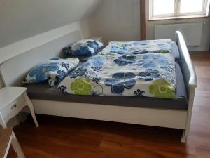 德雷施维茨Ferienwohnung Wald und Weitblick的一张带蓝色和白色床单及枕头的床