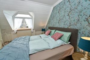乌尔门Ferienwohnungen Eifelstuben mit Charme - am See, nahe Burg的一间卧室配有一张带蓝色床单的床和一扇窗户。