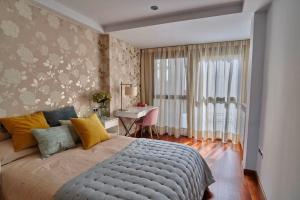 萨拉戈萨Apartamento Plaza España的一间卧室配有一张床、一张书桌和一个窗户。