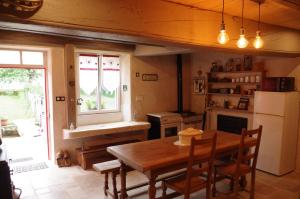 ArchettesChambres d'hôtes du Ruisseau d'Argent的厨房配有木桌和冰箱。
