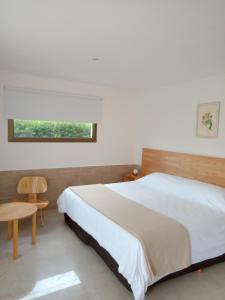 塞拉德洛斯帕德雷斯Chacras de Sierra的一间卧室配有一张床、一张桌子和一个窗户。