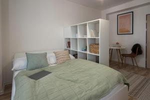 科希策Symple apartments的一间卧室设有一张床和一个书架