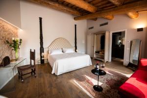 卡洛诺拉阿克里Magari Estates Hotel的卧室配有白色的床和红色沙发