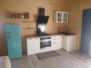 JeżyceRanczo u Jarka的厨房配有蓝色冰箱和白色橱柜
