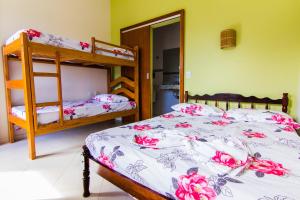 阿布拉奥Harmoni Hostel & Pousada的一间卧室配有两张双层床,铺着粉红色的鲜花