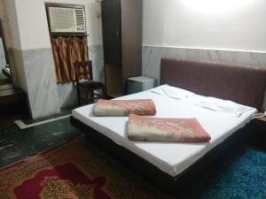 古瓦哈提Hotel Prince的一张床上有两个枕头的房间