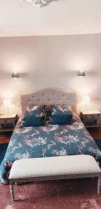 Saint-Aubin-de-LuignéL'Aubinoise的一间卧室配有一张带蓝色枕头的大床