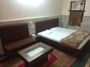 古瓦哈提Hotel Prince的小房间设有一张床和一张桌子