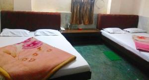 古瓦哈提Hotel Prince的两张位于酒店客房的床,上面有毛巾