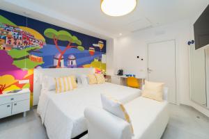 阿马尔菲Amalfi Centro的卧室配有白色的床和色彩缤纷的墙壁