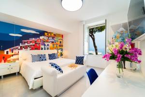 阿马尔菲Amalfi Centro的卧室配有白色的床和花瓶