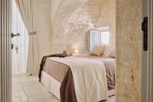 洛科罗通多1783 Dimora d'Epoca的一间卧室配有一张石墙床