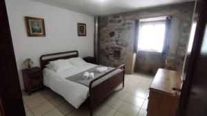 Antigo de ArcosCasa Entre as Serras的一间卧室配有一张床,上面有两条毛巾