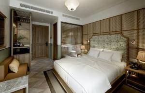 河内La Passion Hanoi Hotel & Spa的一间带白色大床的卧室和一间浴室
