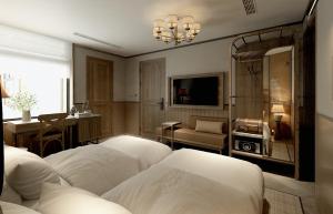 河内La Passion Hanoi Hotel & Spa的一间卧室配有三张床、一台电视和一张沙发