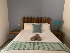 乌姆塔塔Cycad Stay的一间卧室配有一张大床和两条毛巾