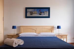 法维尼亚纳Orsola Apartments的一间卧室配有蓝色的床和2条毛巾