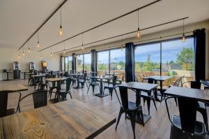 索尔格河畔利勒内翁酒店的餐厅设有桌椅和大窗户。