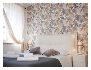 瓜尔多卡塔内奥RESIDENCE IL GROTTINO的卧室配有白色床和花卉壁纸