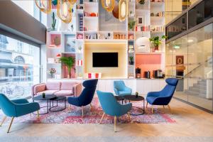根特B&B HOTEL Gent Centrum的大堂设有粉红色的沙发和蓝色的椅子