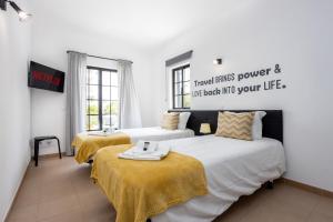 拉戈斯Best Guest Residence的一间设有两张床的客房,墙上有标志