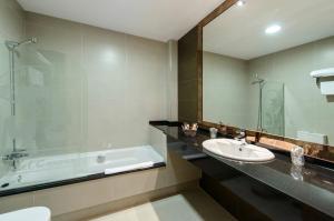 Iboya坎昆阿维莱斯汽车旅馆的带浴缸、水槽和浴缸的浴室