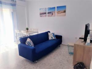 科尼尔-德拉弗龙特拉Conil Centro & Playa, descanso perfecto, Aire Ac y WIFI -SOLO FAMILIAS Y PAREJAS-的客厅设有蓝色沙发,配有电视