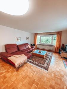 肯普滕Grüntenblick的客厅配有红色的沙发和桌子