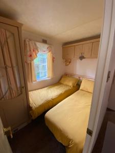 莫伊尔弗雷“Ty Hir Caravan” Moelfre的一间小卧室,配有两张床和窗户