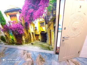 敖德萨Garden Love on Deribasovskaya的一道门,画着一个种有紫色花朵的庭院