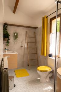 CazilhacGites de la Lurette - T3 lumineux et spacieux dans cadre calme et verdoyant的浴室设有黄色卫生间和水槽。