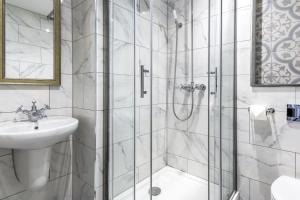 科尔切斯特乔治酒店的带淋浴和盥洗盆的白色浴室