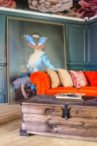 科尔切斯特乔治酒店的一张女画,头上有一个蝴蝶,躺在沙发后面