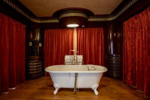 布鲁塞尔伊斯佩兰策酒店的配有红色窗帘的客房内的浴缸