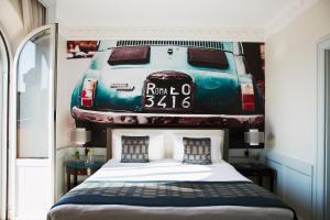 罗马Hotel Indigo Rome - St. George, an IHG Hotel的卧室配有一张床铺,墙上挂有汽车