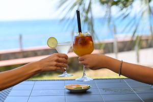 皮肖塔Villaggio Stella del Sud & Resort的两个人在桌上拿着饮料