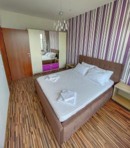 马马亚Sunset Sea View Apartament的一间卧室配有一张带白色床单和镜子的床